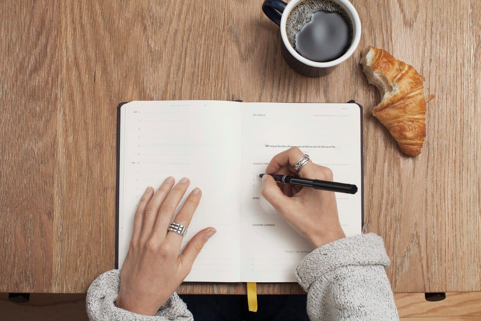 Hands writing a plan in a notebook
